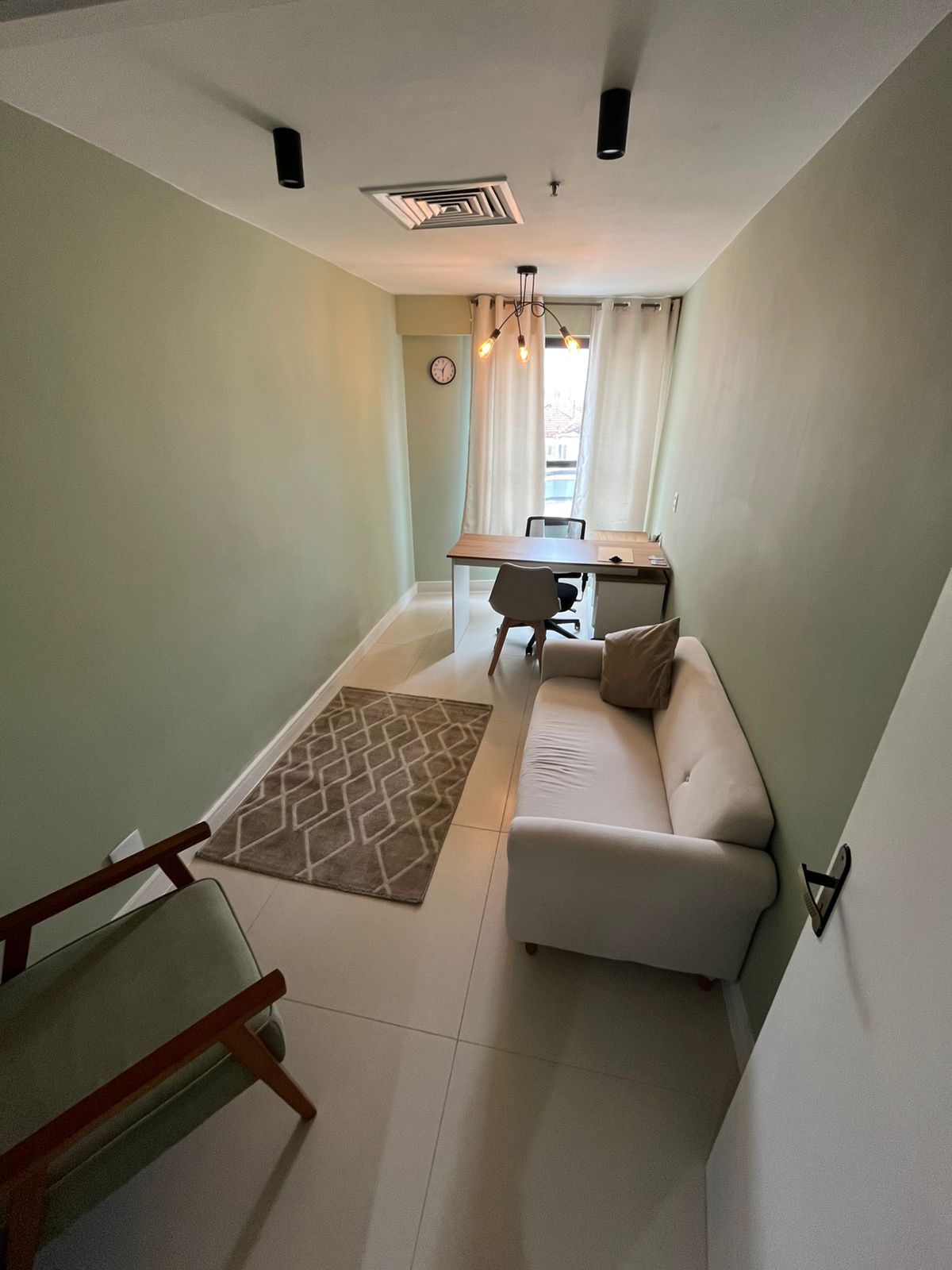 Sala Oliva - ambiente acolhedor com sofá e mesa de trabalho